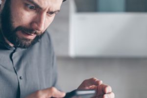 The Great Bitcoin & Crypto Heists - A History - Man stressed over phone